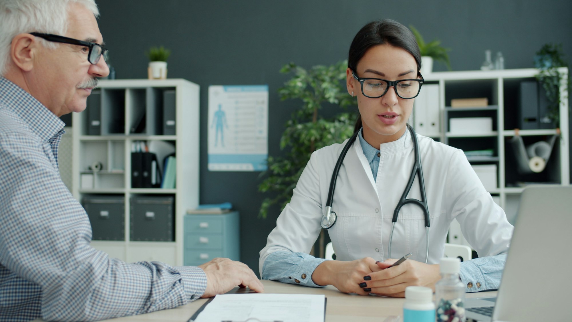 A podiatrist listening to a patient
